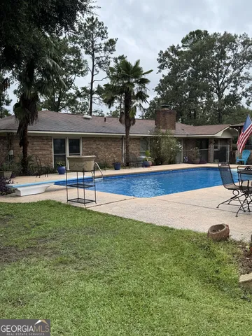 a swimming pool with outdoor seating and yard