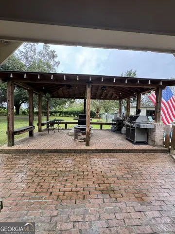 a view of a patio with a table and chairs under an umbrella