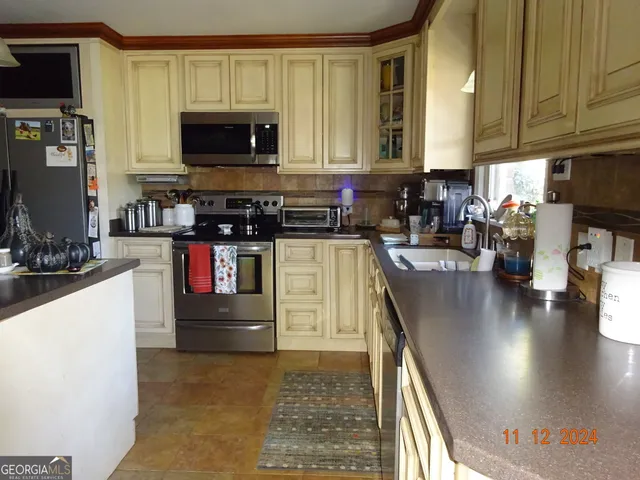 a kitchen with stainless steel appliances granite countertop a stove a sink a microwave and refrigerator