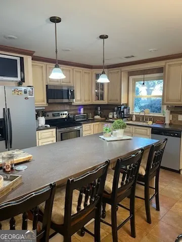 a kitchen with stainless steel appliances granite countertop a stove a sink a dining table and chairs with the wooden floor