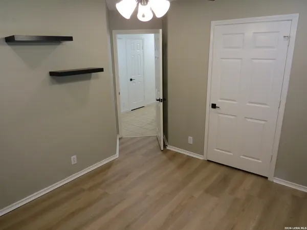 an empty room with wooden floor and closet