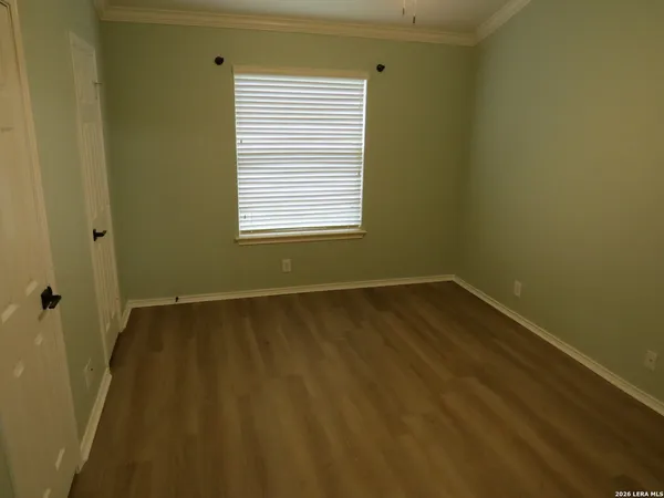 a view of a room with wooden floor and a window