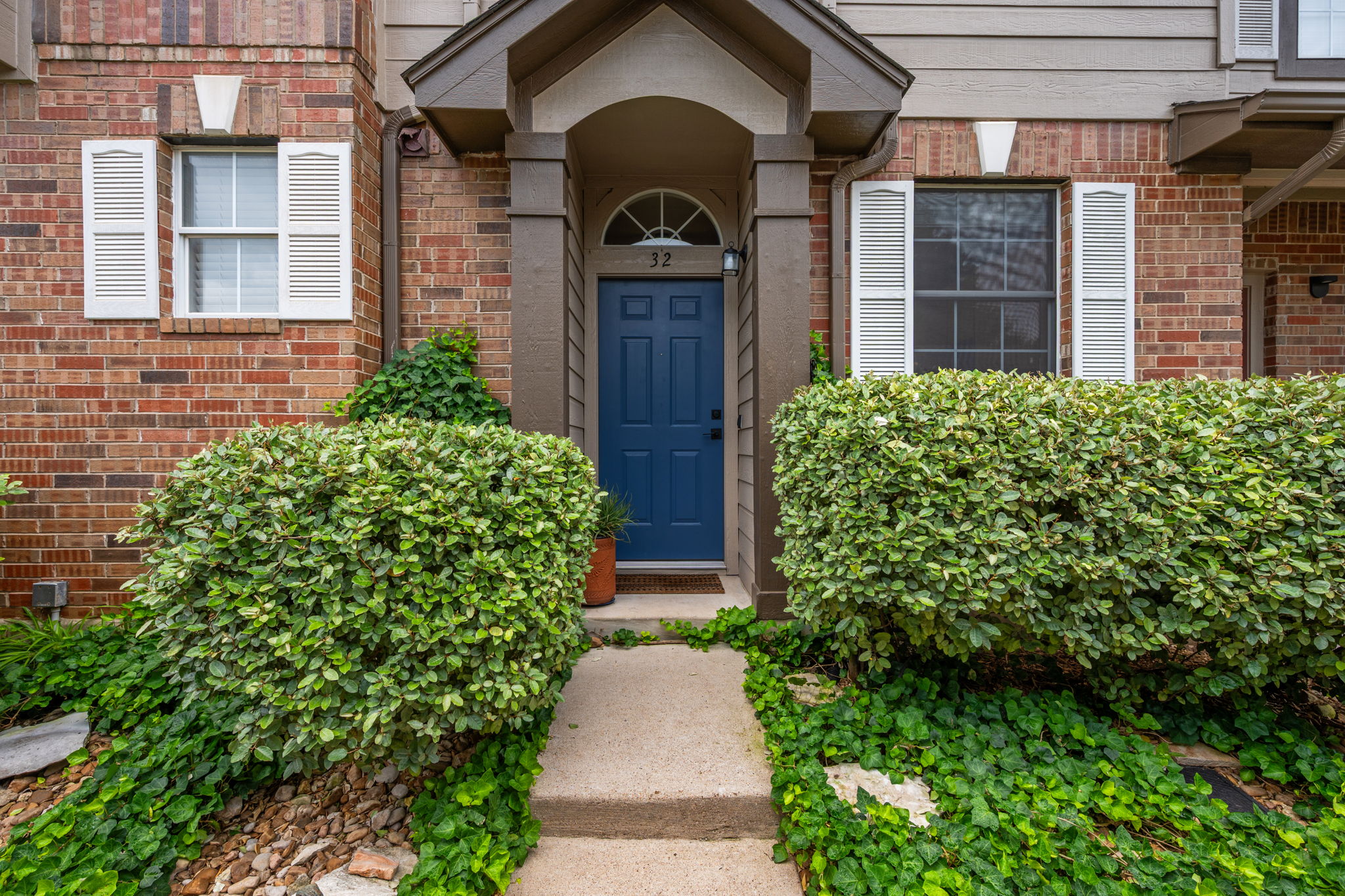 12401 Los Indios Trail, Unit 32 Austin, TX 78729 - Photo 1 of 39 A welcoming entry framed by lush greenery.