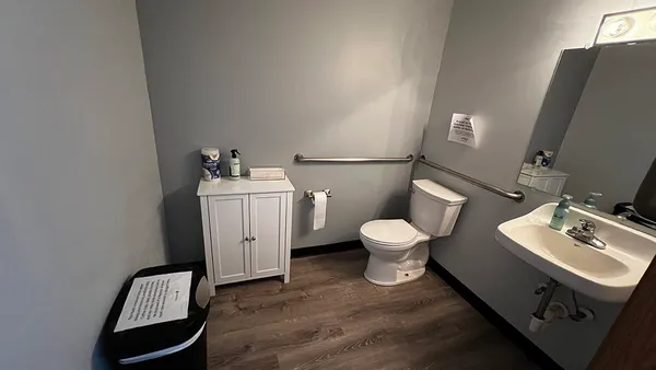 a bathroom with a toilet sink and mirror