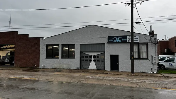 a view of a hallway with wooden floor and a bathroom