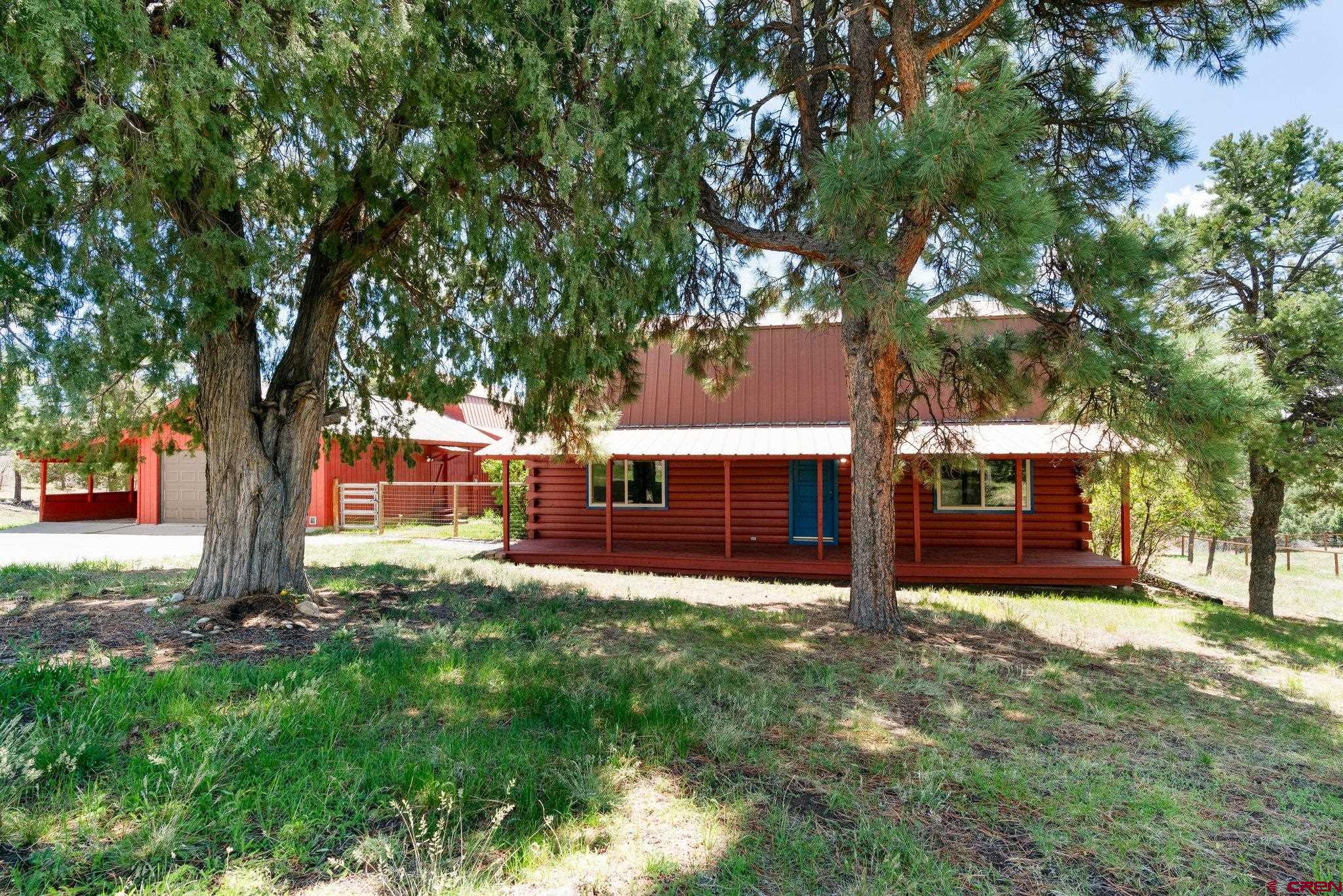 front view of a house with a yard and an trees
