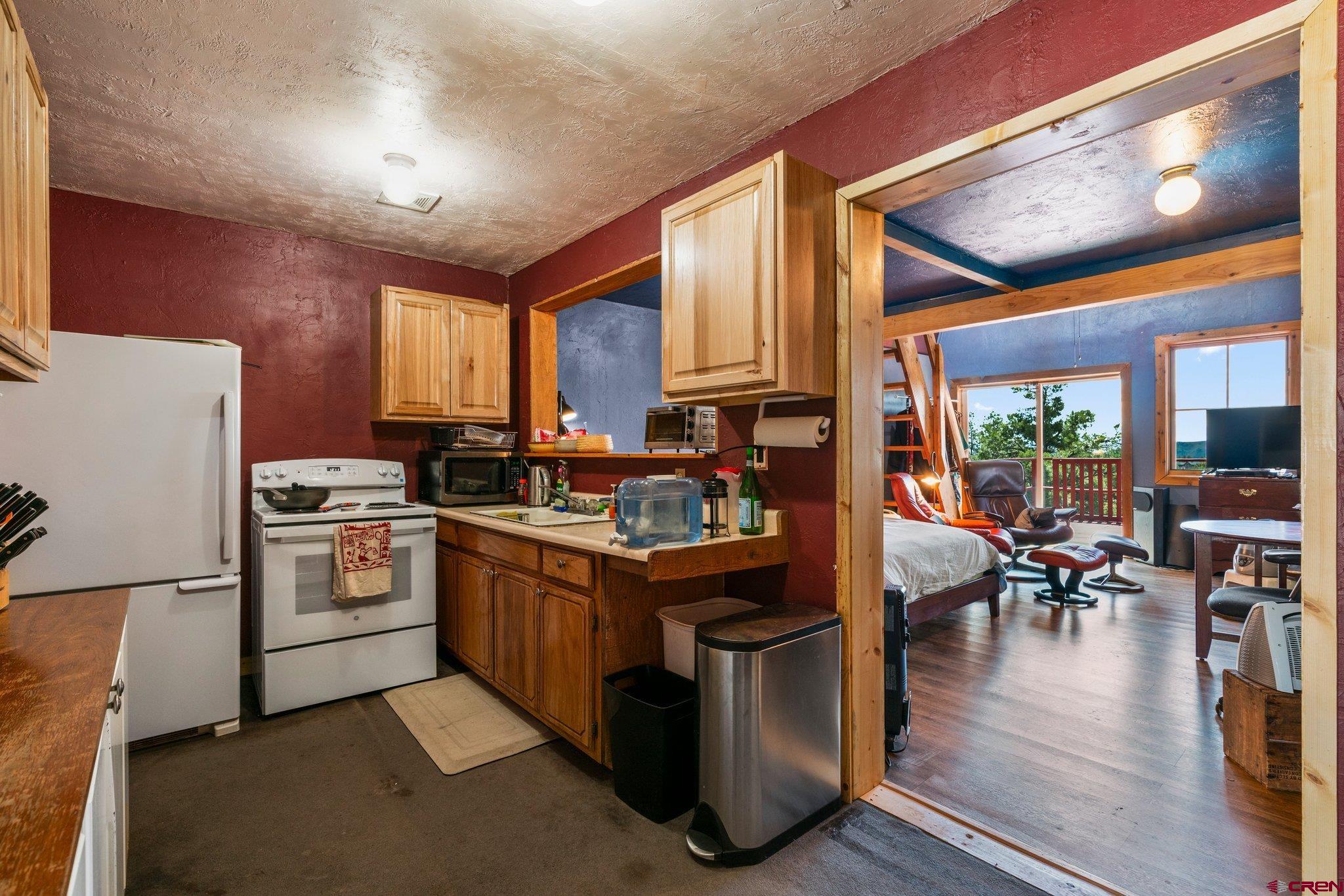 340 Ridge Road Durango, CO 81303 - Photo 21 of 35 a kitchen with stainless steel appliances granite countertop a stove top oven a refrigerator a dining table and chairs with wooden floor