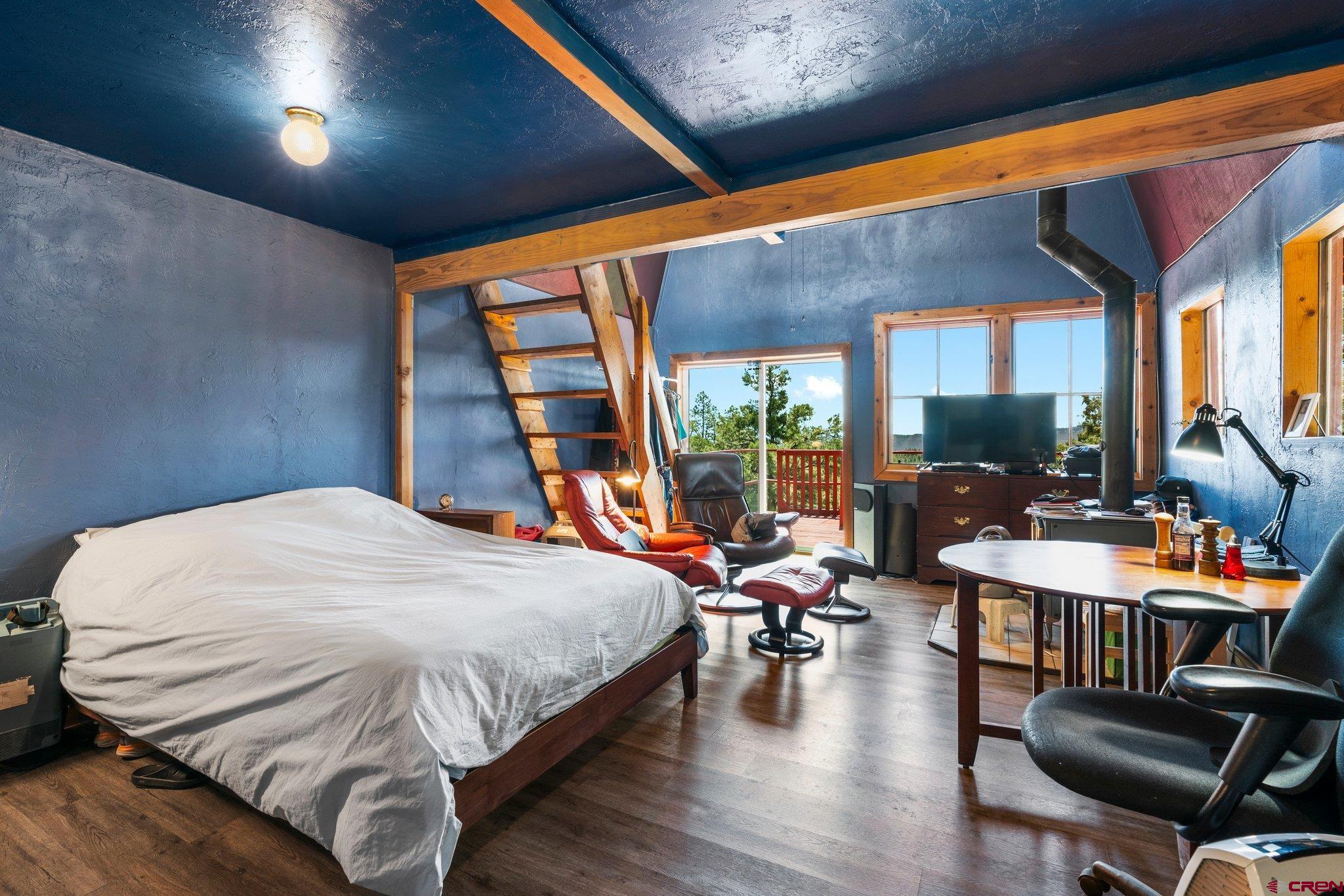 340 Ridge Road Durango, CO 81303 - Photo 23 of 35 a bedroom with a bed and large windows