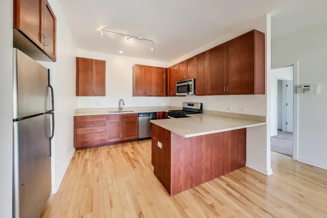 a kitchen with stainless steel appliances granite countertop a refrigerator a sink and a stove