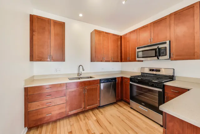 a kitchen with stainless steel appliances granite countertop wooden cabinets and a stove top oven