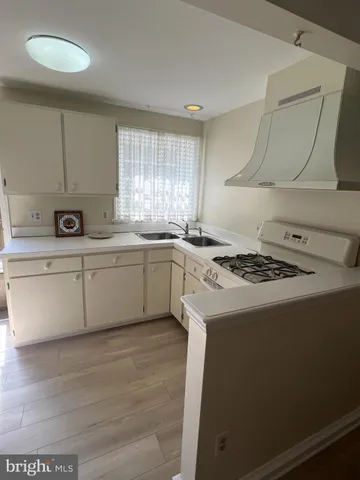 a white kitchen with a stove top oven
