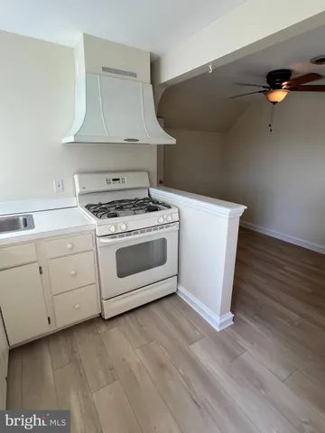 a white stove top oven sitting inside of a kitchen