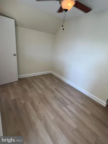 a view of an empty room with wooden floor and a cabinet