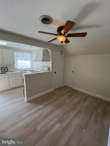 an empty room with wooden floor air conditioner and windows