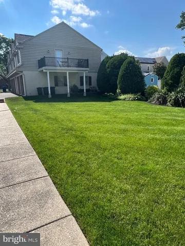 a view of a house with a yard and potted plants