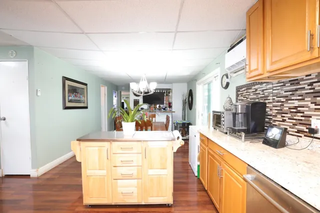 a view of a kitchen with kitchen island stainless steel appliances a sink and counter space