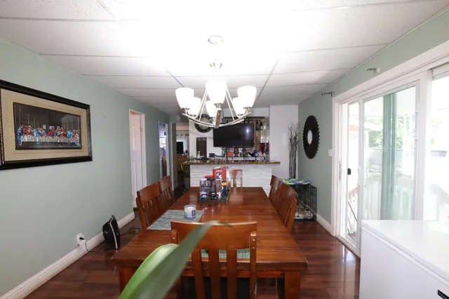 a view of a dining room with furniture a chandelier and wooden floor