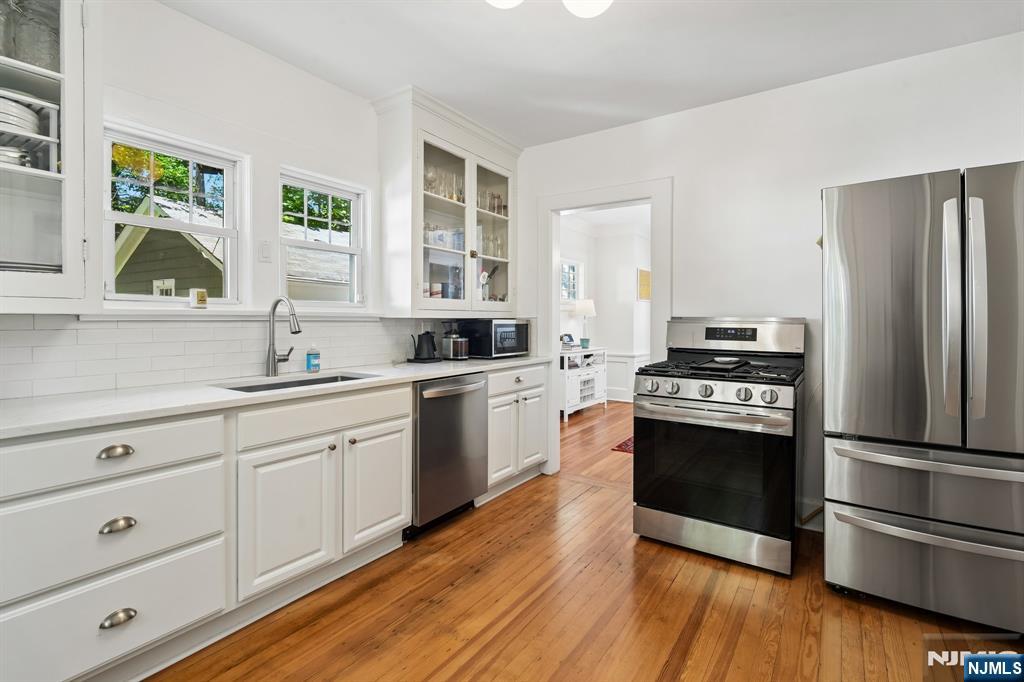 72 Central Avenue Montclair, NJ 07042 - Photo 14 of 36 a kitchen with stainless steel appliances and wooden cabinets