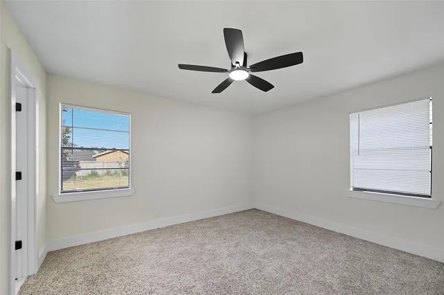 an empty room with a window and a fan