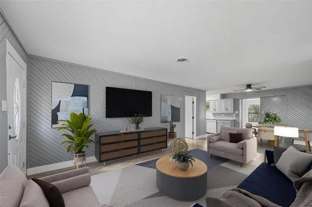 a living room with furniture potted plant and a flat screen tv