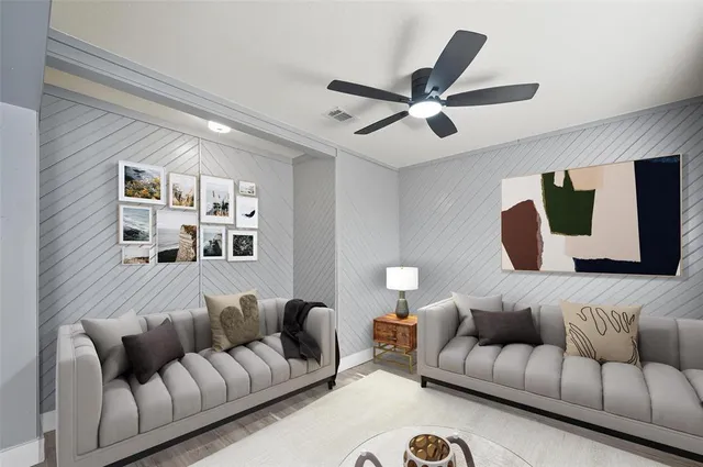 a living room with furniture and a ceiling fan