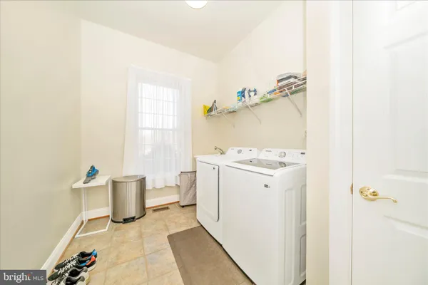 a large white kitchen with stainless steel appliances granite countertop a lot of counter space and wooden floors