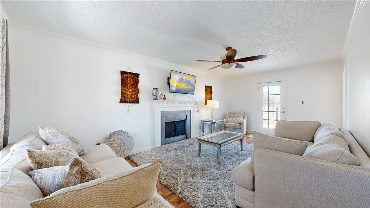 1405 Harvey Johnson Road Raleigh, NC 27603 - Photo 3 of 30 Living Room with a stylish wood-burning fireplace and ceiling fan. Living Room