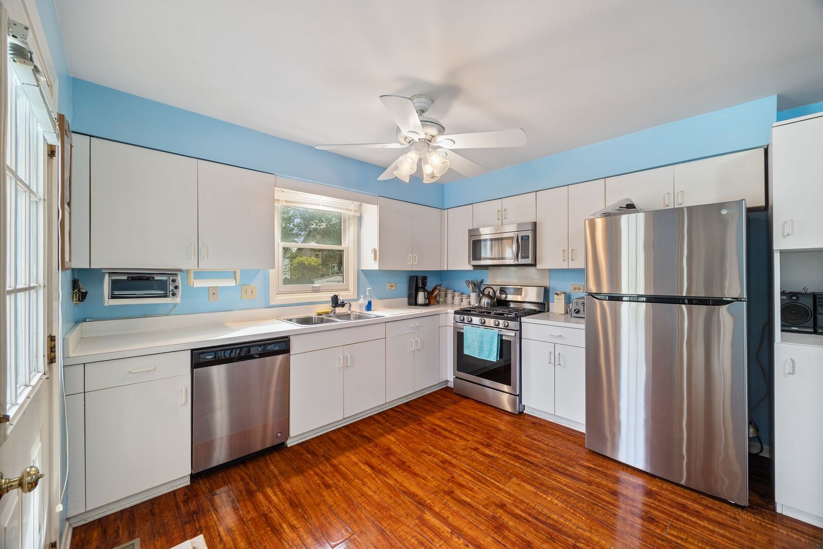 701 Garth Road Wheeling, IL 60090 - Photo 9 of 23 a kitchen with a refrigerator a sink dishwasher a stove and white cabinets with wooden floor