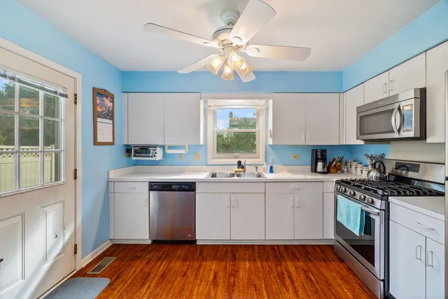 a kitchen with a white cabinets and wooden floor
