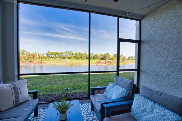 a living room with furniture and a floor to ceiling window