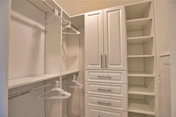 a view of walk in closet with empty racks
