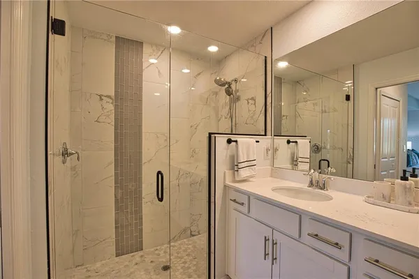 a bathroom with a shower sink and mirror