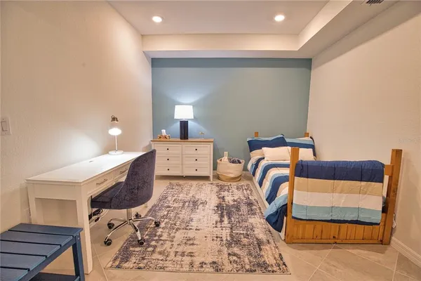a bedroom with a bed and a lamp on dresser
