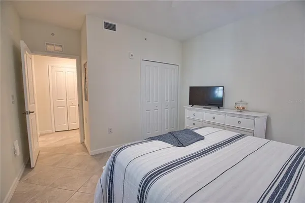 a bedroom with a bed and a flat screen tv