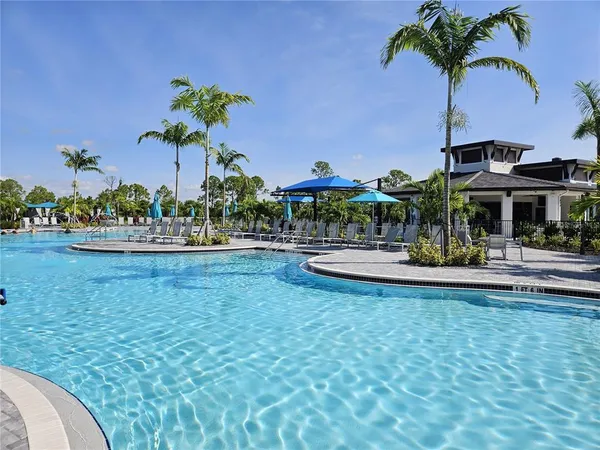 a view of a swimming pool with a lawn chairs under an umbrella
