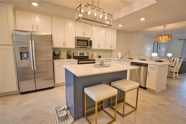 a kitchen with a sink a counter space appliances and cabinets