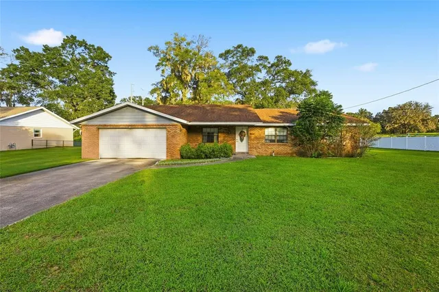 a front view of a house with a yard and trees