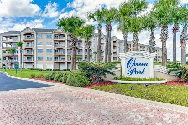 a sign board with a big yard and palm trees