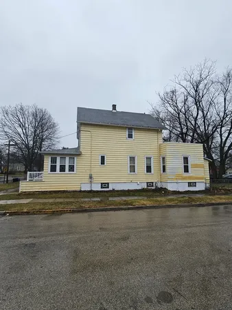 a front view of a house with a garden and a car parked