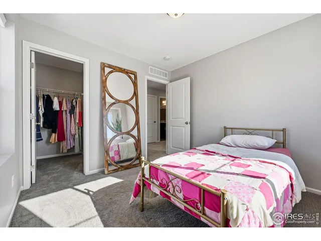 a bedroom with a bed and a painting on the wall