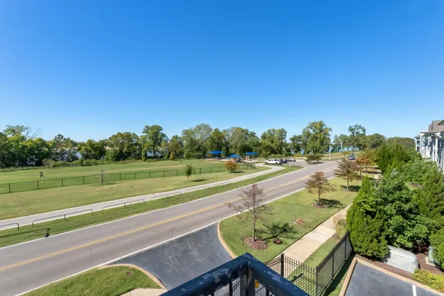 a view of an apartment with a swimming pool and a yard