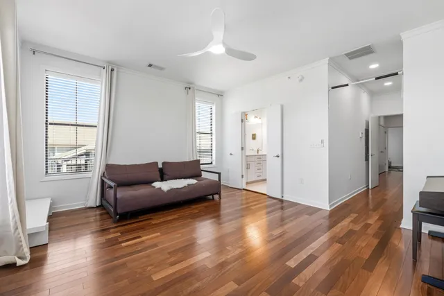 a living room with furniture and a wooden floor