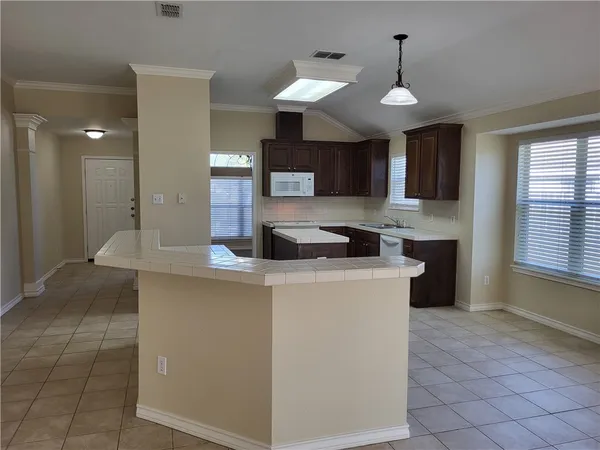 a kitchen with stainless steel appliances granite countertop a sink a stove and a refrigerator
