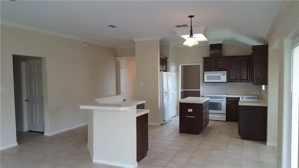 a kitchen with stainless steel appliances kitchen island granite countertop a refrigerator and a stove top oven