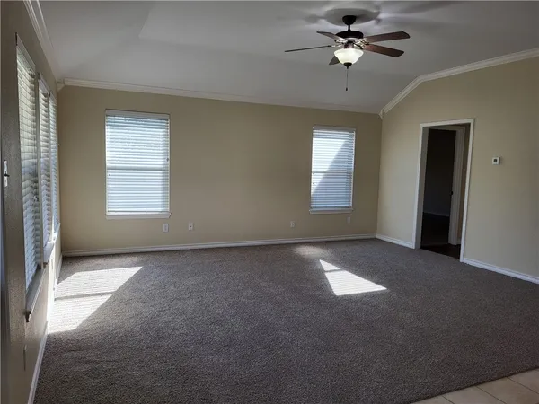 a view of a big room with windows and chandelier fan
