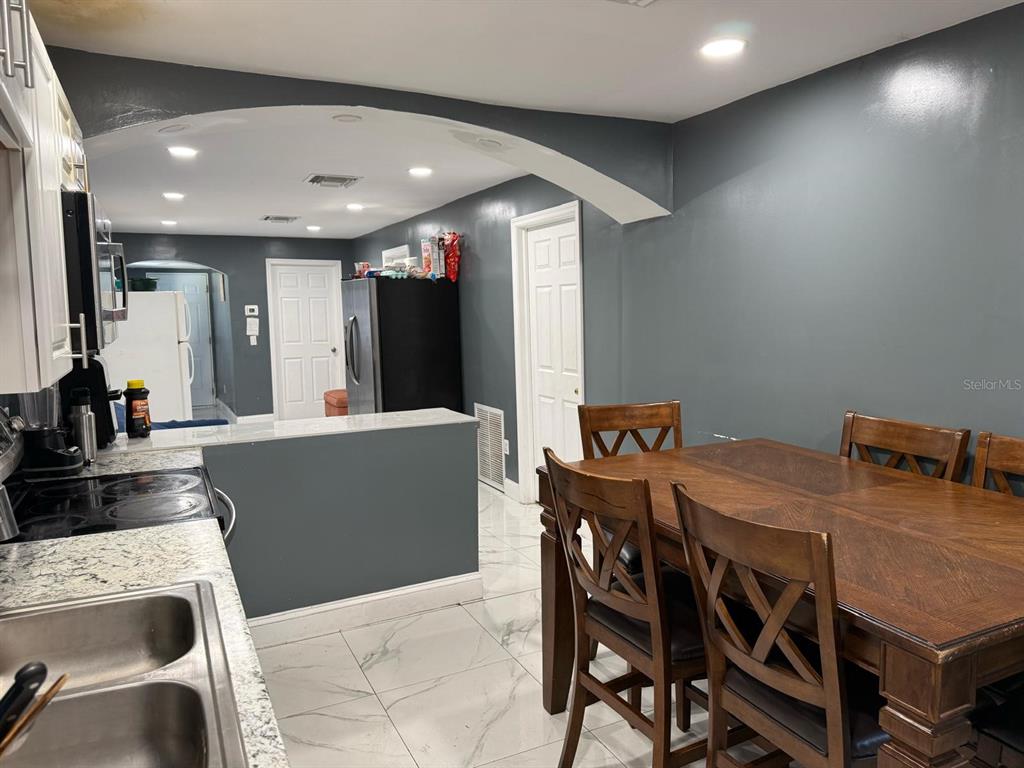 414 Spring Avenue Arcadia, FL 34266 - Photo 15 of 36 a kitchen with stainless steel appliances kitchen island granite countertop a sink a refrigerator and chairs