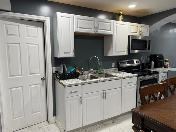 a kitchen with stainless steel appliances granite countertop a sink a stove and cabinets