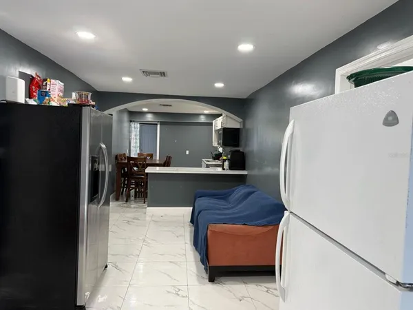 a view of kitchen with furniture and a refrigerator