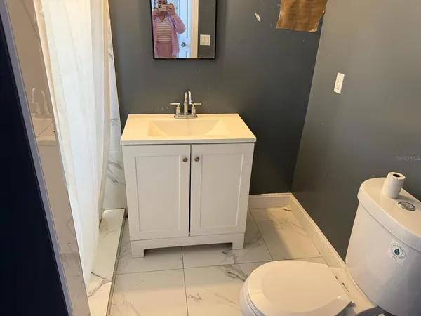 a bathroom with a toilet sink and mirror