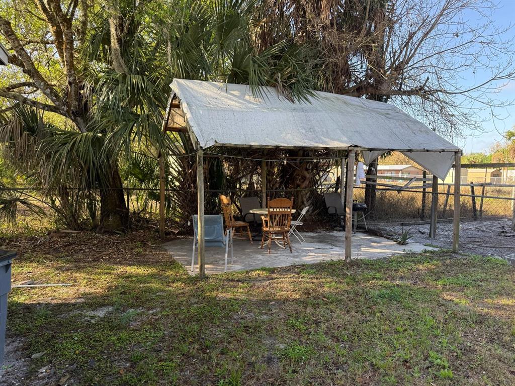 414 Spring Avenue Arcadia, FL 34266 - Photo 35 of 36 a view of a patio with table and chairs under an umbrella